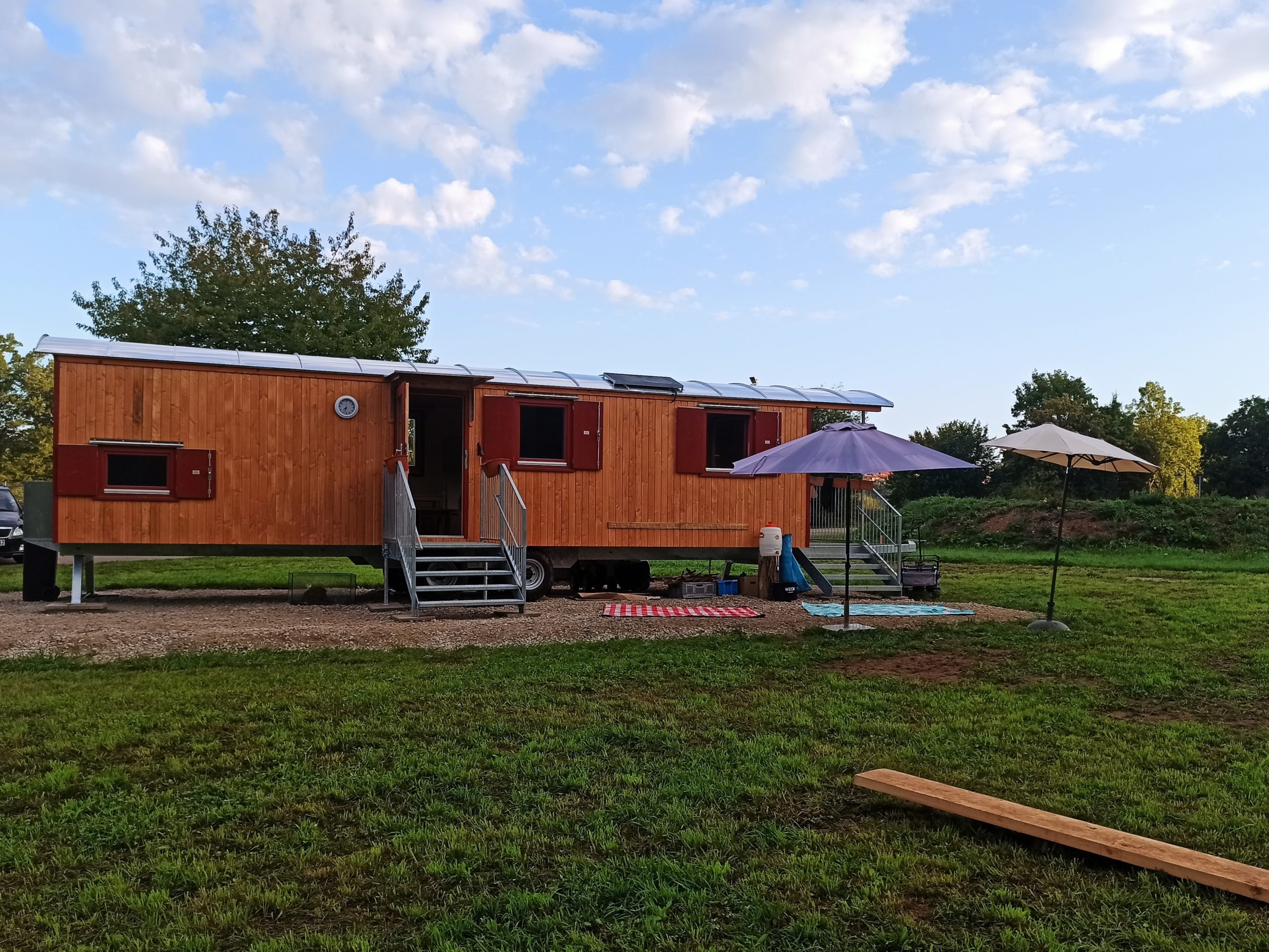 Der Bauwagen des Naturkindergartens Pliezhausen, umgeben von grüner Natur.