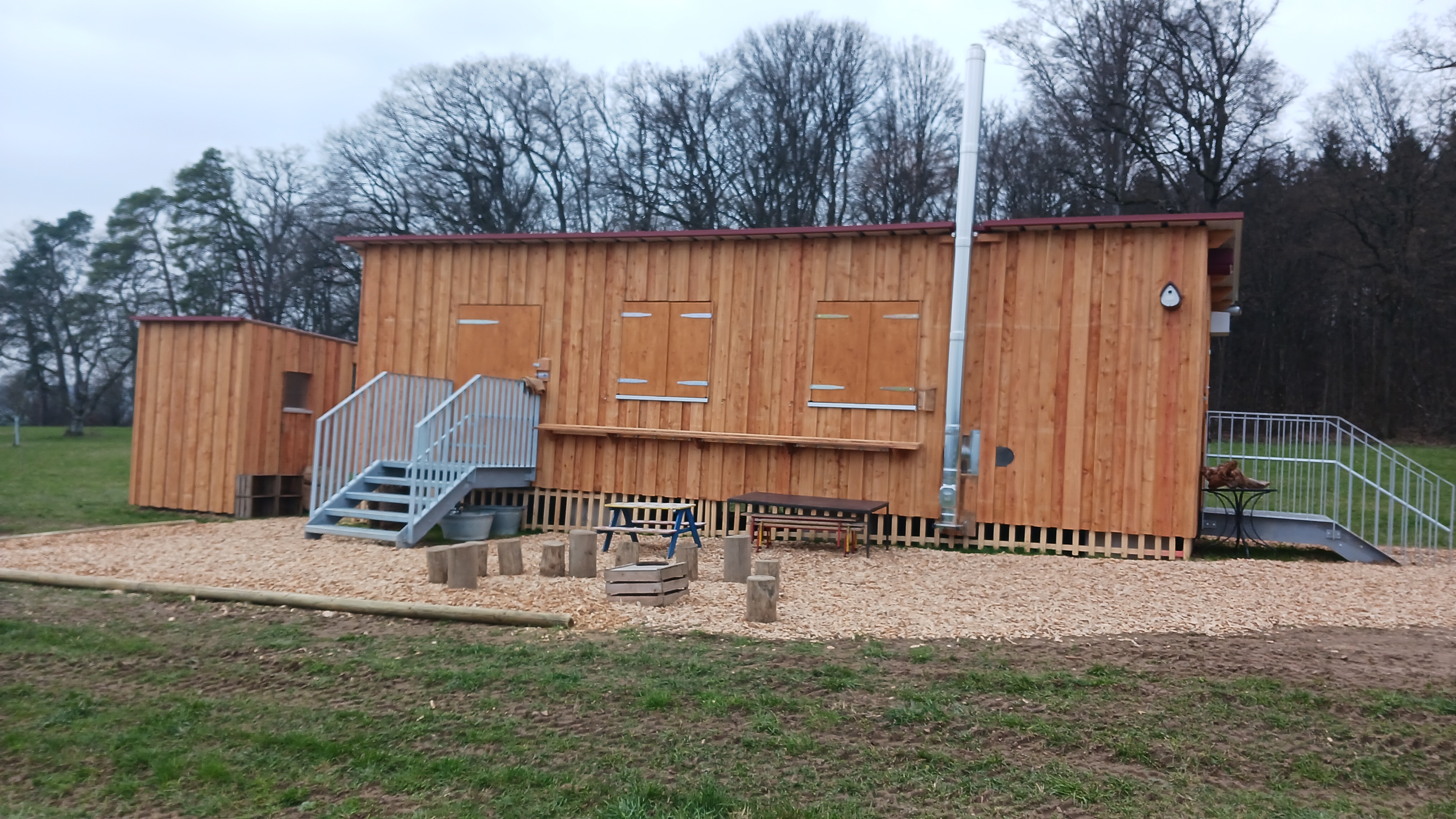 Die beiden Bauwagen des Naturkindergartens Reinerspatzen auf der Bempflinger Höhe, umgeben von Wiesen.